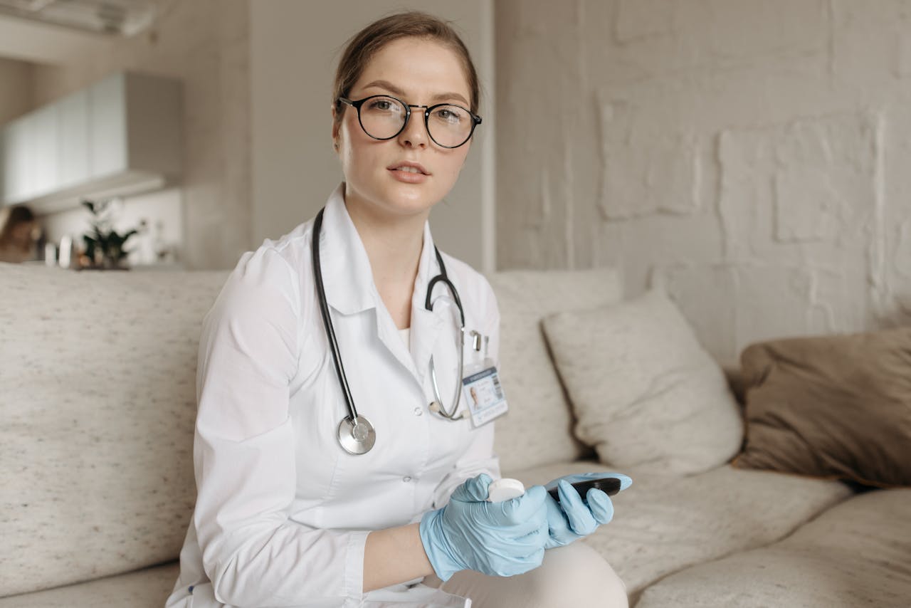 our-story-02 Female doctor with glucometer on a sofa, assessing blood sugar control indoors.
